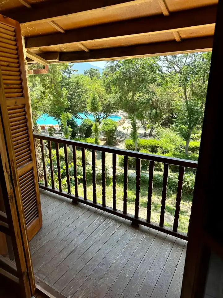 Poolside Bungalow balcony view over pool and gardens